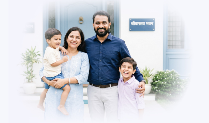 Couple smiling with kids and home in background